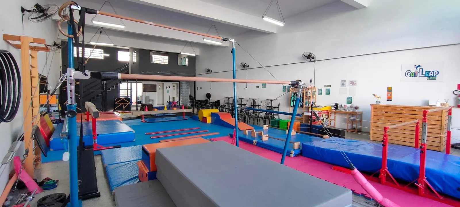 Ginásio da CatLeap Gym com barras, trampolim e colchões